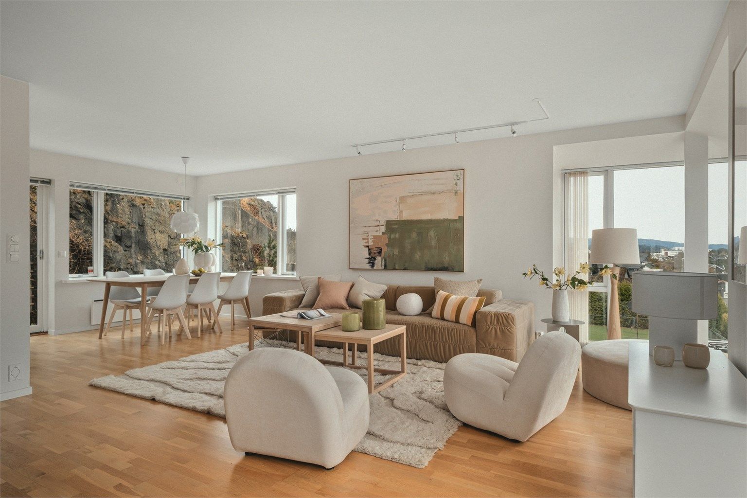 Rommet oppleves luftig og harmonisk med rikelig lysinnslipp fra store vindusflater