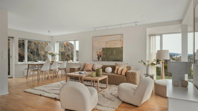 Rommet oppleves luftig og harmonisk med rikelig lysinnslipp fra store vindusflater