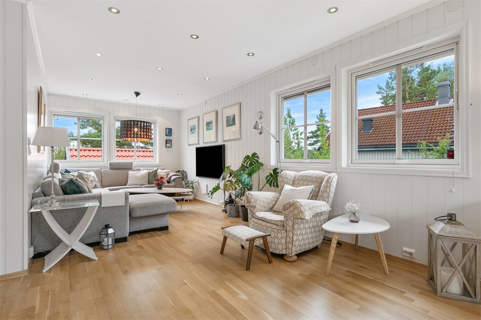 Lys og innbydende stue med god takhøyde, store vindusflater og klassisk enstavs parkett.