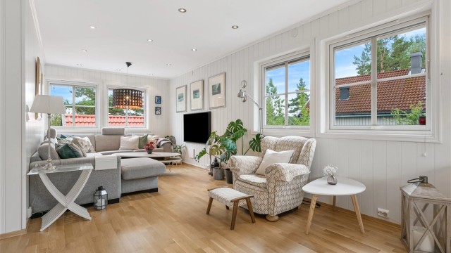 Lys og innbydende stue med god takhøyde, store vindusflater og klassisk enstavs parkett.