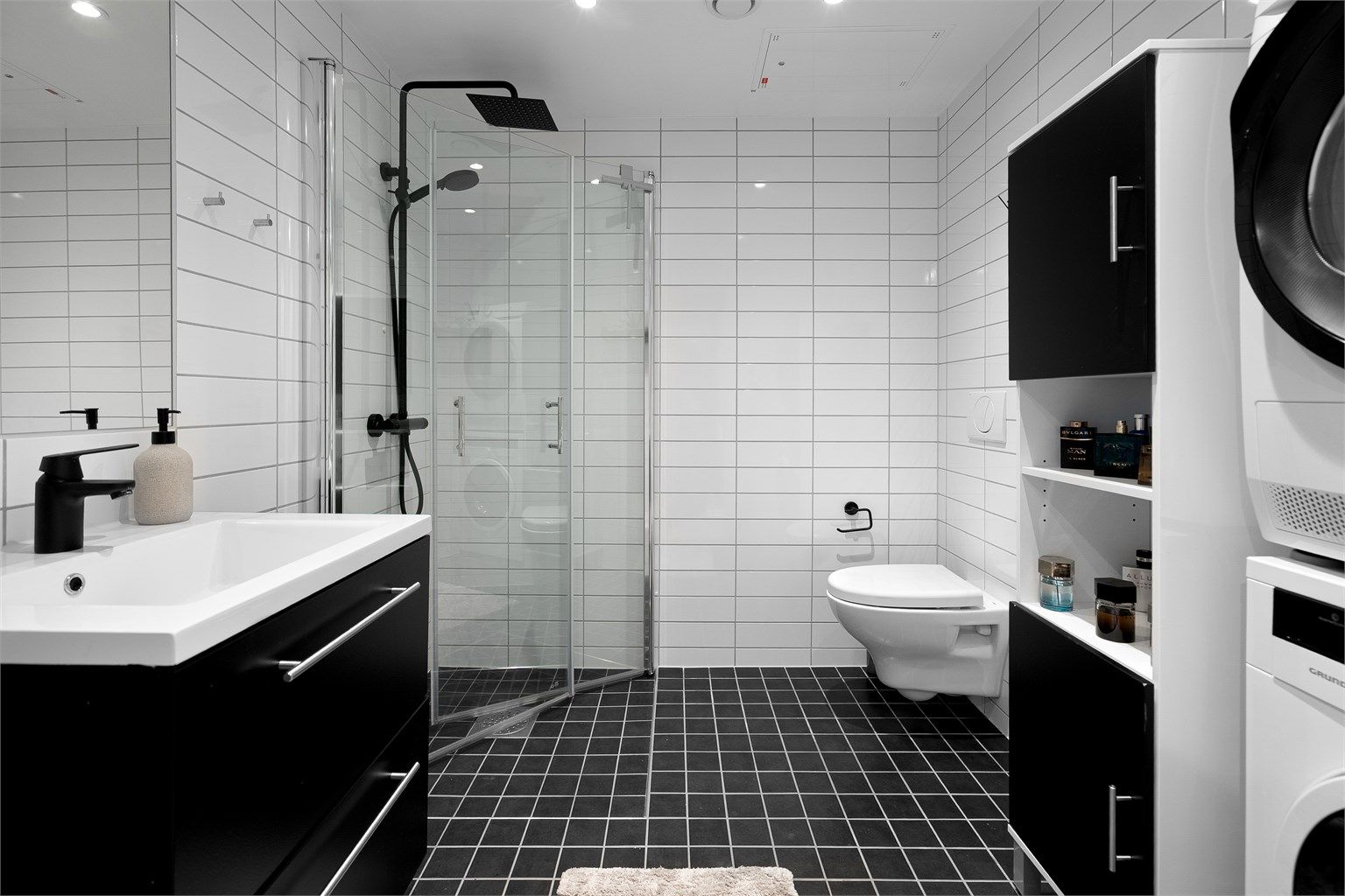 Badet er en stilren og praktisk prefabrikkert baderomsmodul fra byggeår, med flislagte overflater og behagelig gulvvarme.