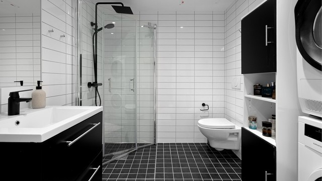 Badet er en stilren og praktisk prefabrikkert baderomsmodul fra byggeår, med flislagte overflater og behagelig gulvvarme.