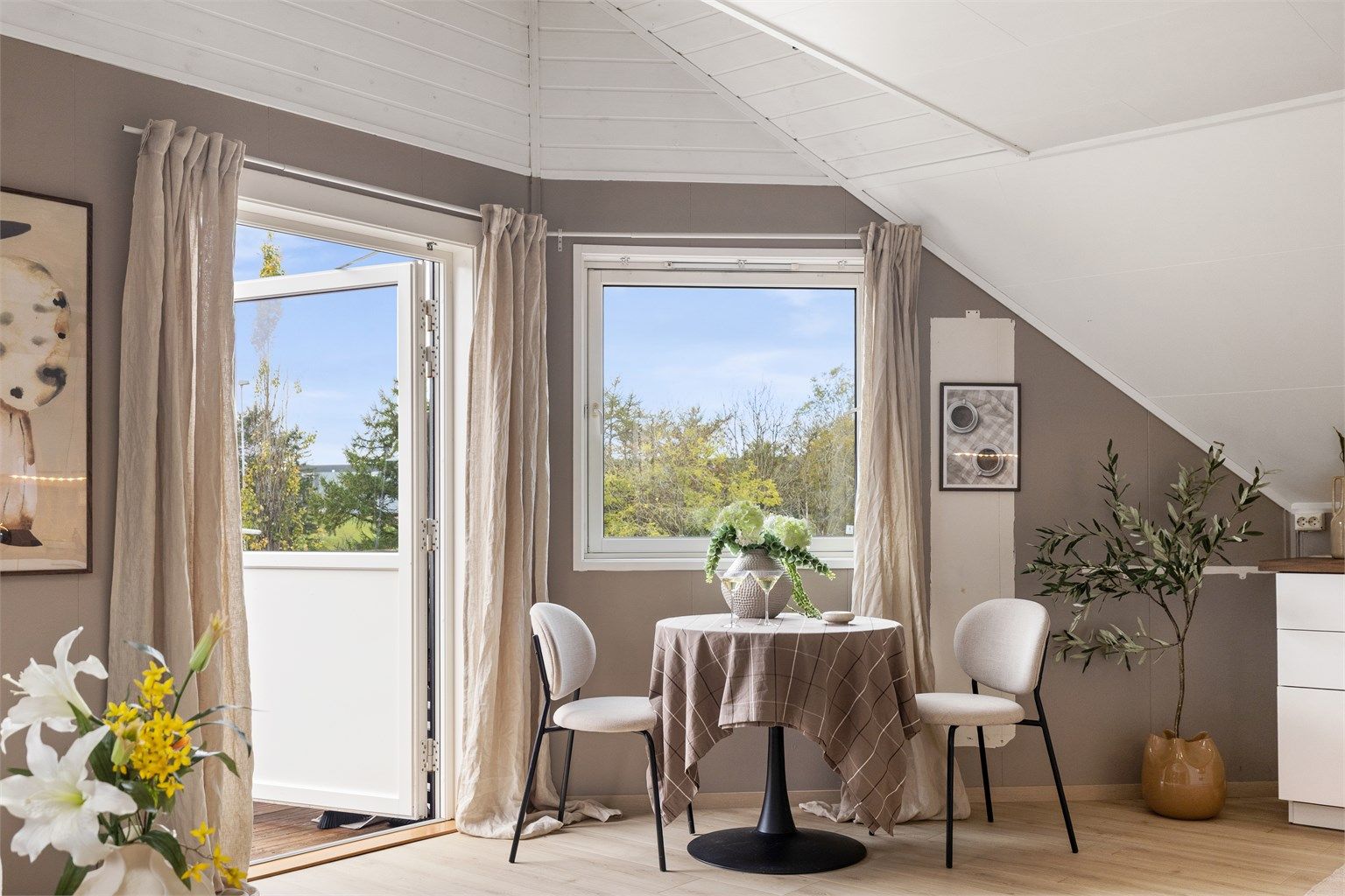 Vindusposten ved spiseplassen vender ut mot nærområdets grønne omgivelser.