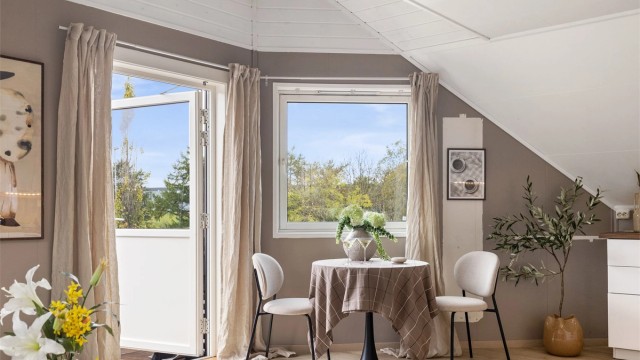 Vindusposten ved spiseplassen vender ut mot nærområdets grønne omgivelser.
