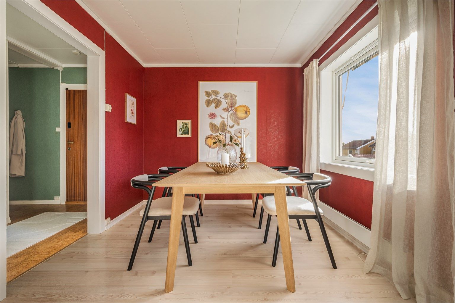 En utvidet åpning mot entréen gjør rommet til en naturlig passasje og et sentralt bindeledd mellom boligens ulike soner.