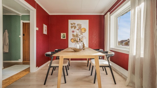 En utvidet åpning mot entréen gjør rommet til en naturlig passasje og et sentralt bindeledd mellom boligens ulike soner.