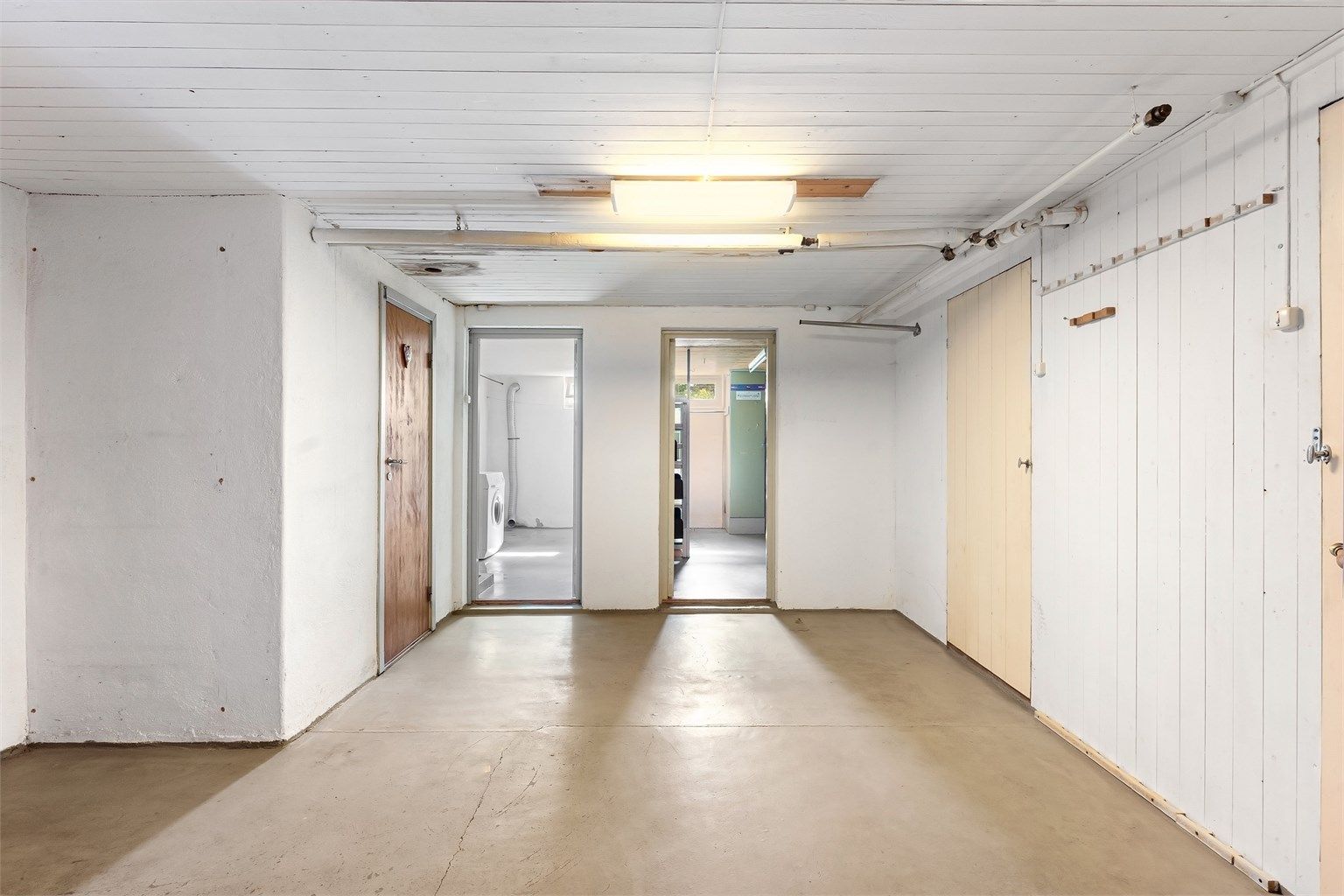Kjelleren inneholder gang, vaskerom, toalettrom og tre boder.