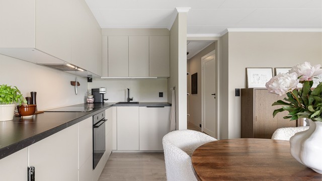 Kjøkkenet har glatte fronter og benkeplate med laminert overflate.