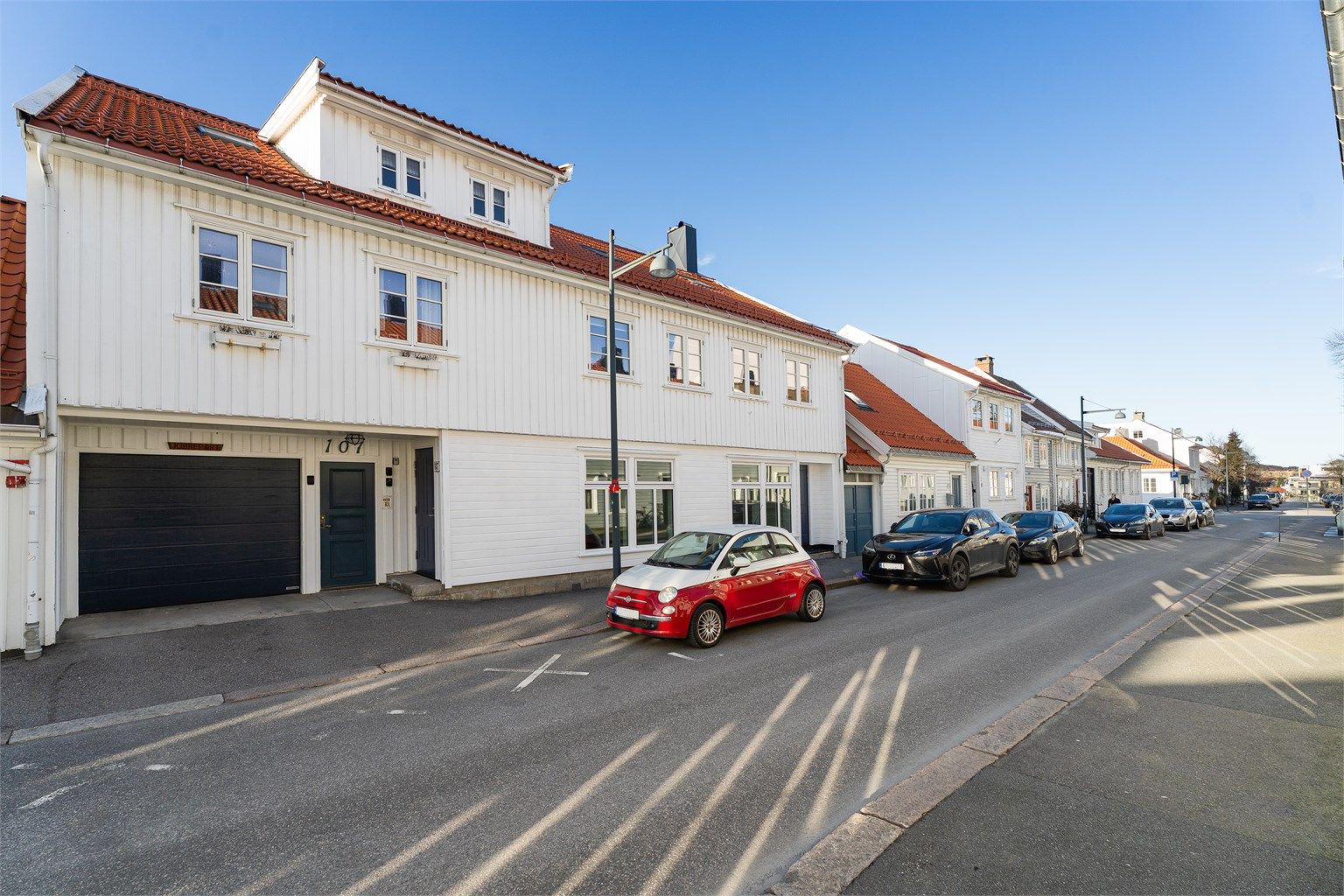 Fasadebilde med dør til felles trappegang og port til bakgård