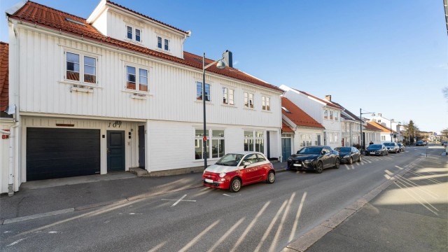 Fasadebilde med dør til felles trappegang og port til bakgård