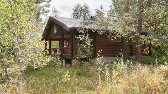 Hytten er oppført i tradisjonelt tømmer og glir naturlig inn i terrenget på naturtomten.