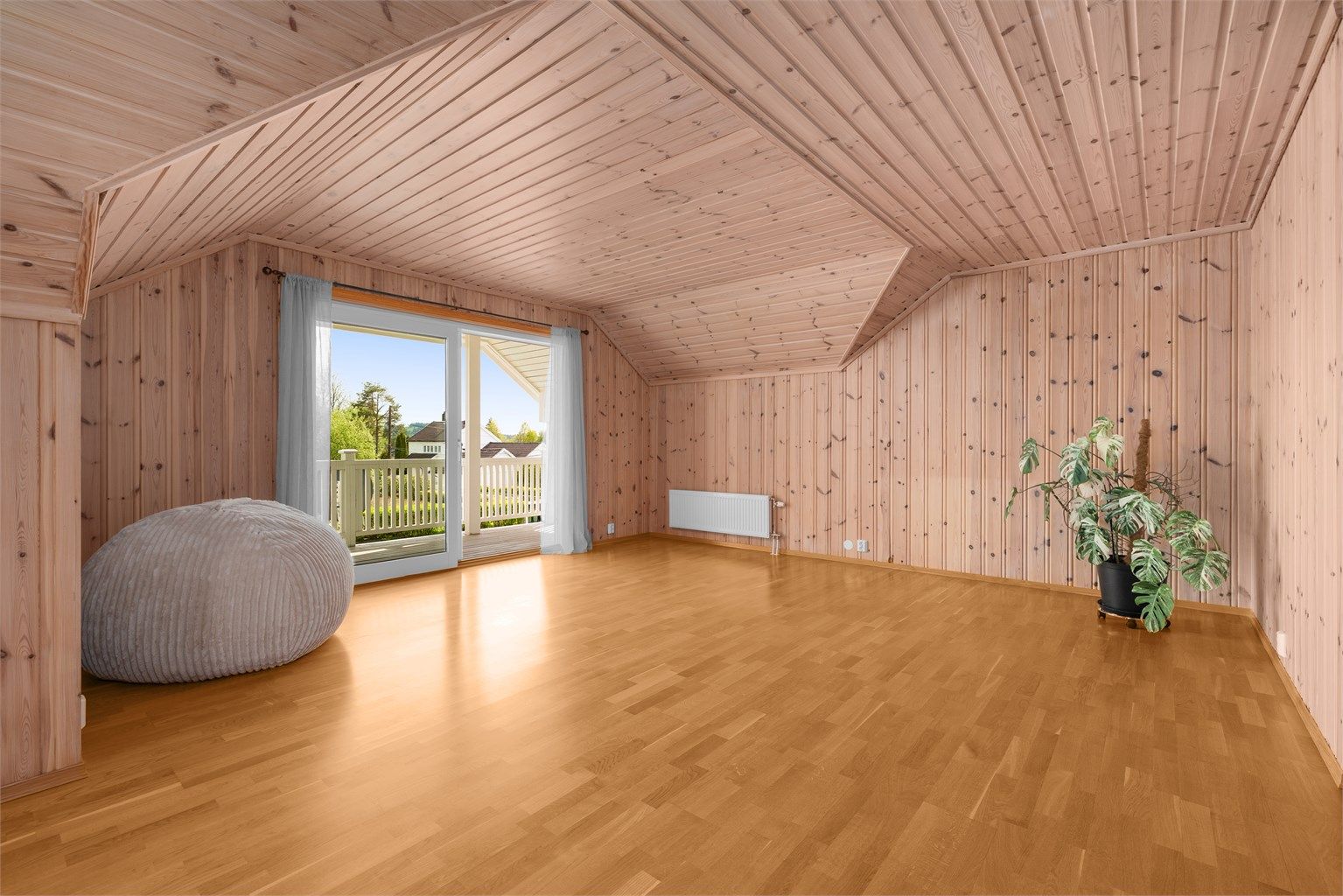 Loftstuen er et stort og anvendelig rom med panel på vegger og i tak.