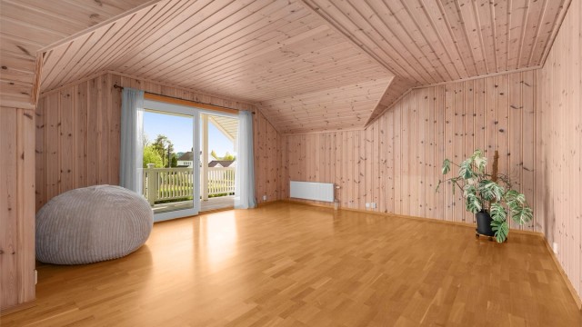 Loftstuen er et stort og anvendelig rom med panel på vegger og i tak.