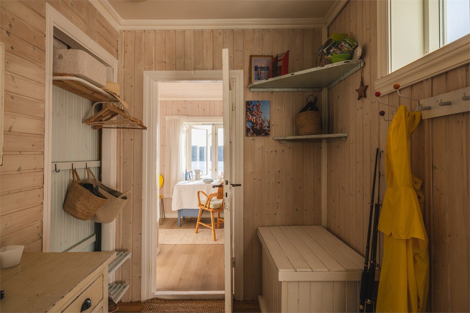 Entreen har malt panel på veggene og direkte siktlinje videre inn mot stuen og sjøen.