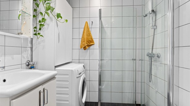 Flislagt bad med elektrisk gulvvarme, downlights i himlingen og opplegg for vaskemaskin – en komplett og velutstyrt baderomsløsning som gir god komfort året rundt.