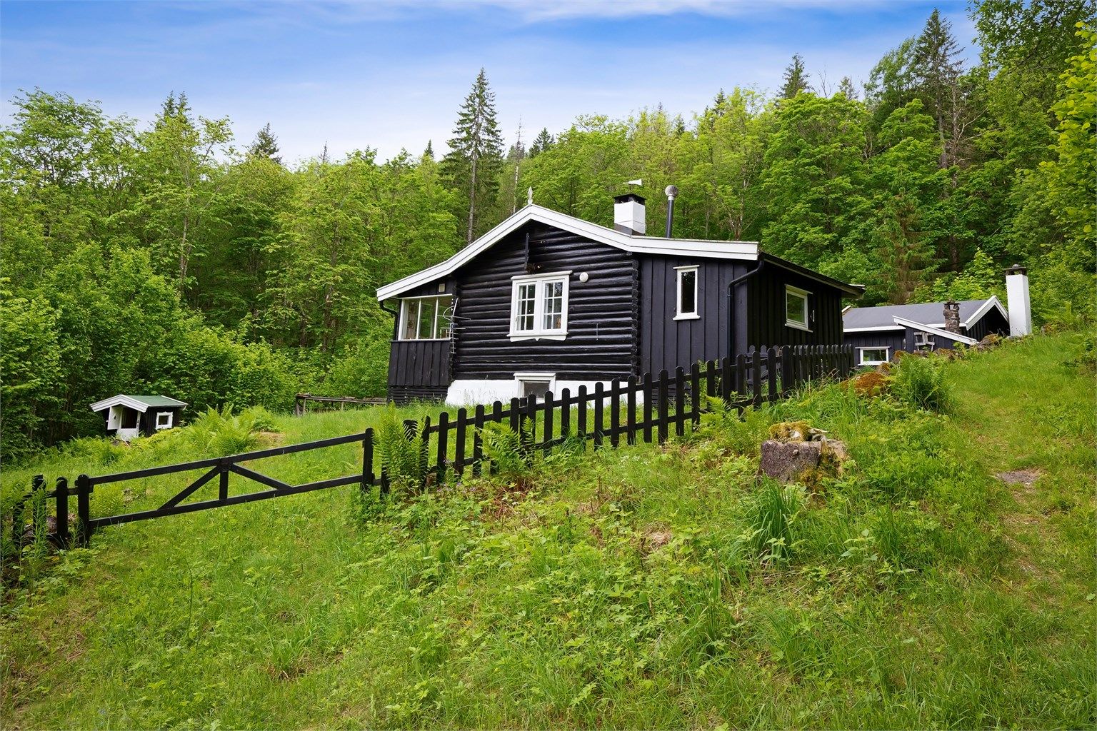 Eiendommen har veirett inn via en privat grusvei og ligger tilbaketrukket på en svakt skrånende naturtomt.