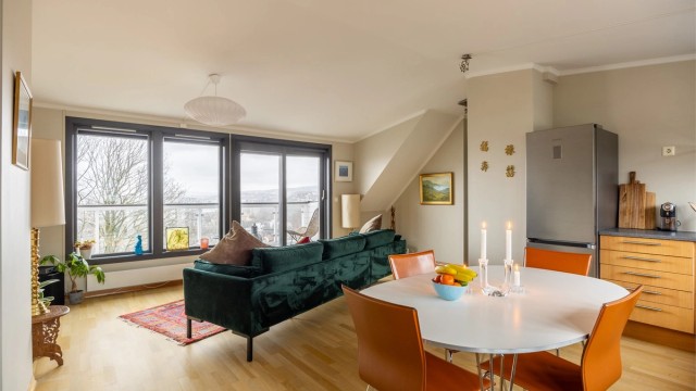 Den åpne løsningen mellom stue og kjøkken skaper en lys og sosial atmosfære.