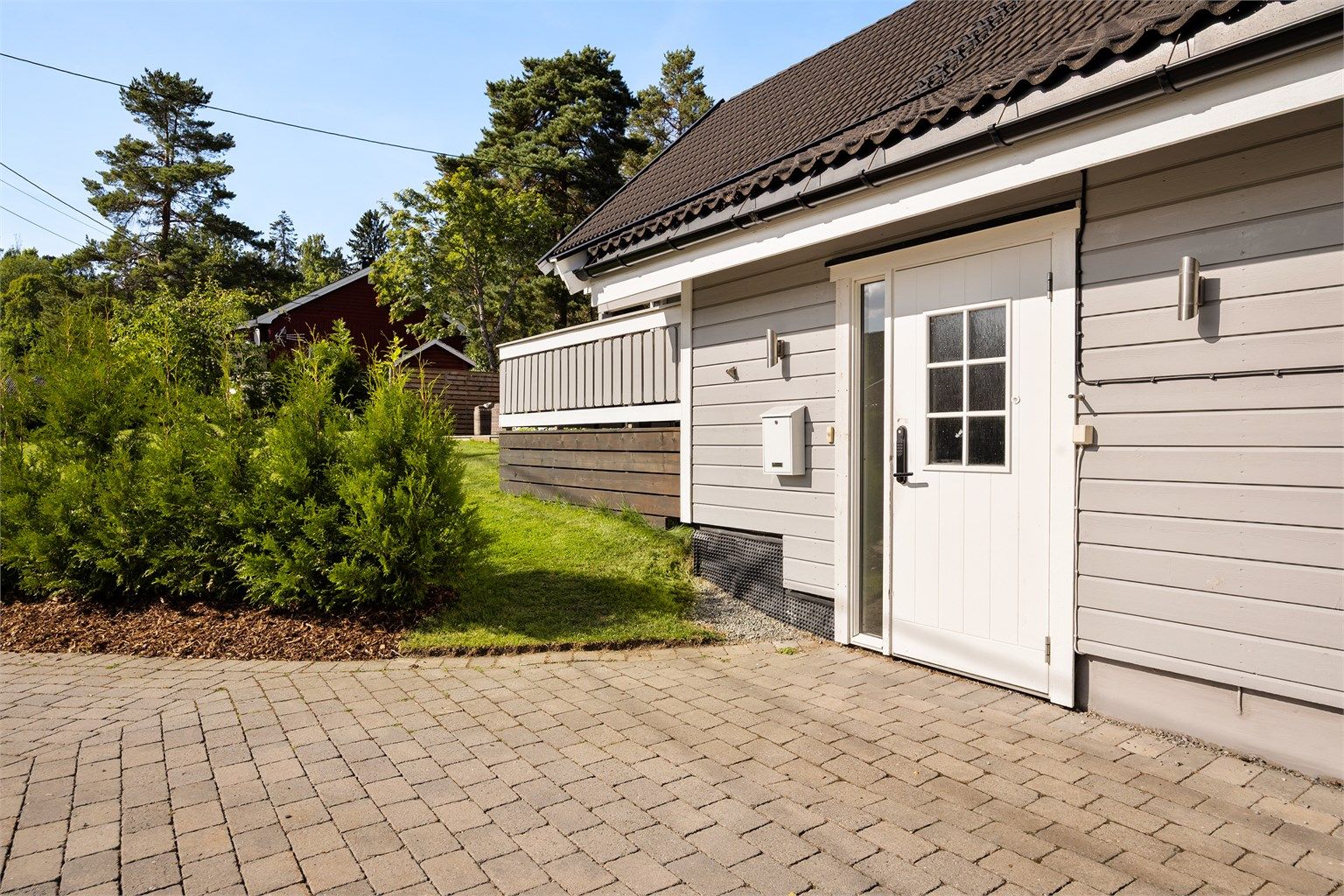 Parkeringsområde ved inngangsparti er belagt med belegningsstein.