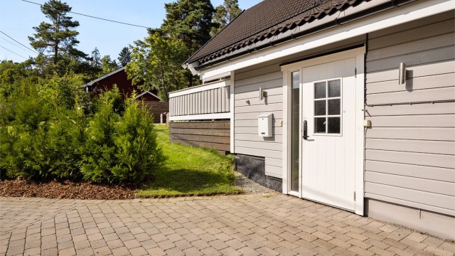 Parkeringsområde ved inngangsparti er belagt med belegningsstein.