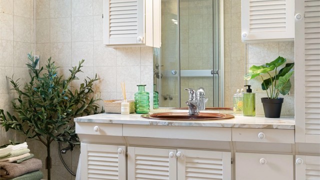 Badet har belegg på gulvet, tapetserte vegger og naturlig ventilasjon.