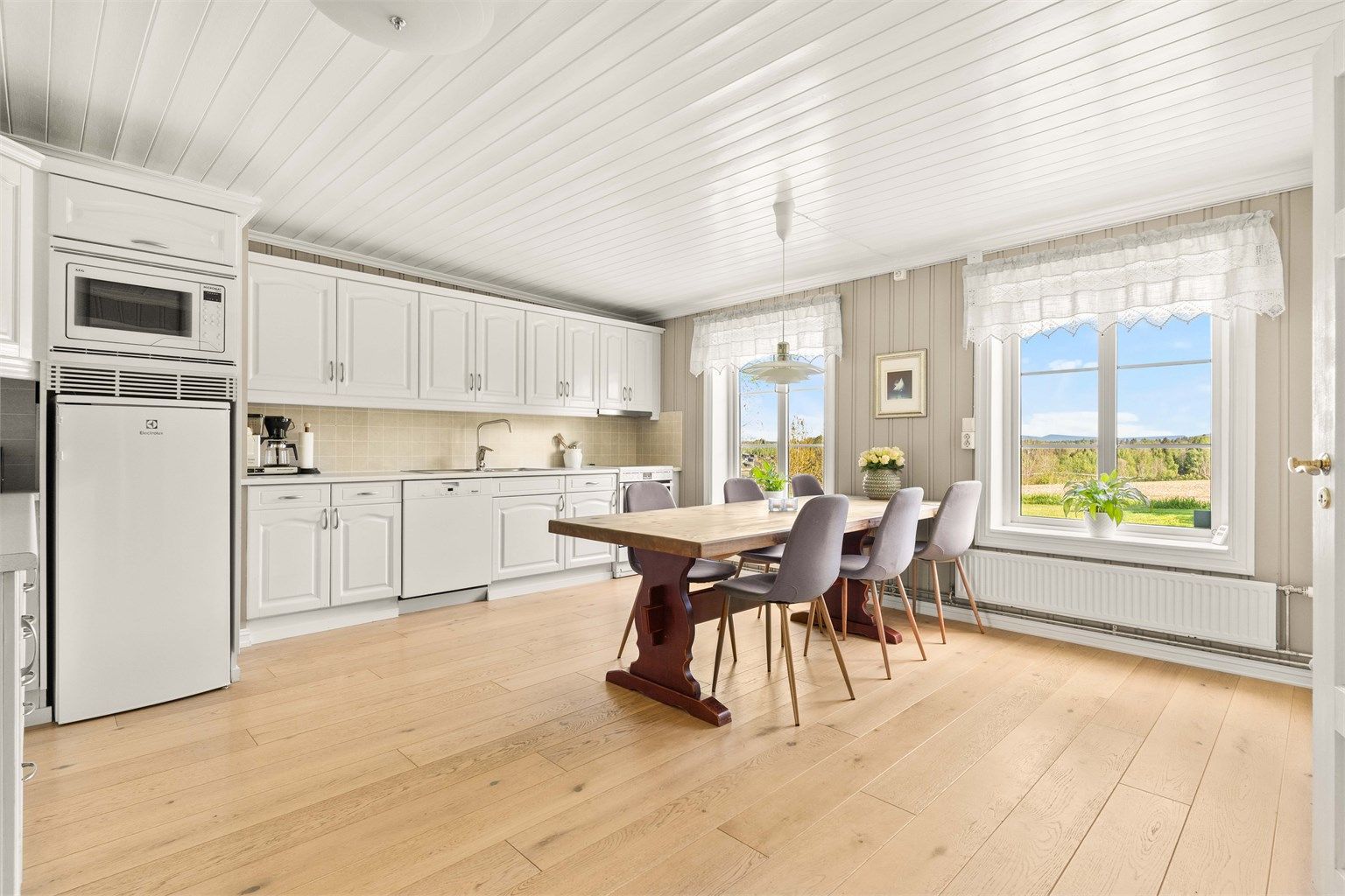 Stort spisekjøkken med parkettgulv og god plass til langbord. Kjøleskap, oppvaskmaskin og komfyr medfølger.