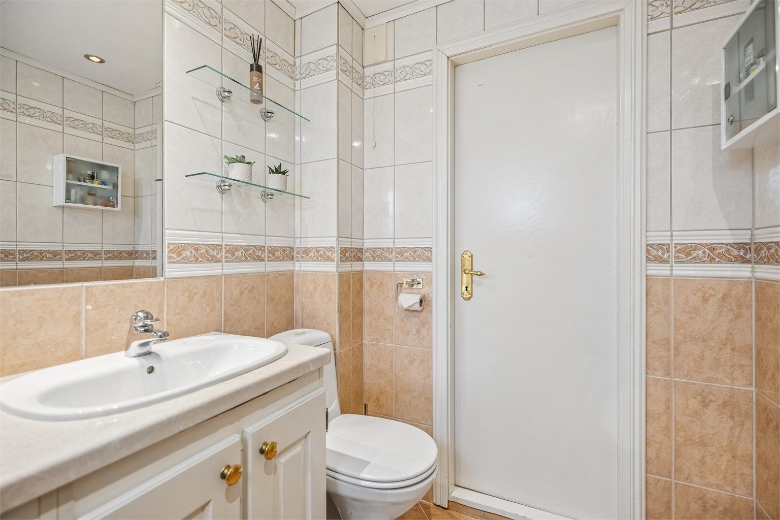 Det er montert glasshyller på hver side av speilet.