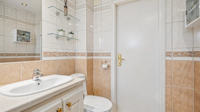 Det er montert glasshyller på hver side av speilet.