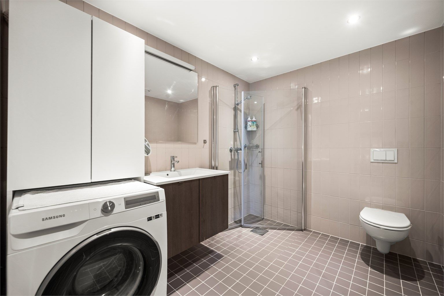 Flislagt bad fra 2022 med vannbåren gulvvarme. Badet har vegghengt toalett, dusjhjørne med glassvegger og opplegg for vaskemaskin.
