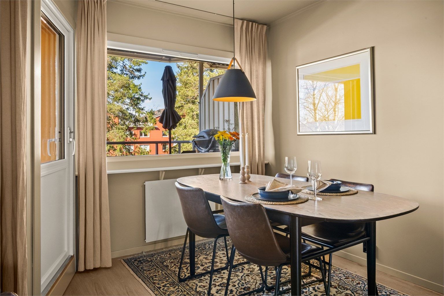 Spiseplassen er naturlig plassert ved vinduet, med enkel tilgang til balkongen.