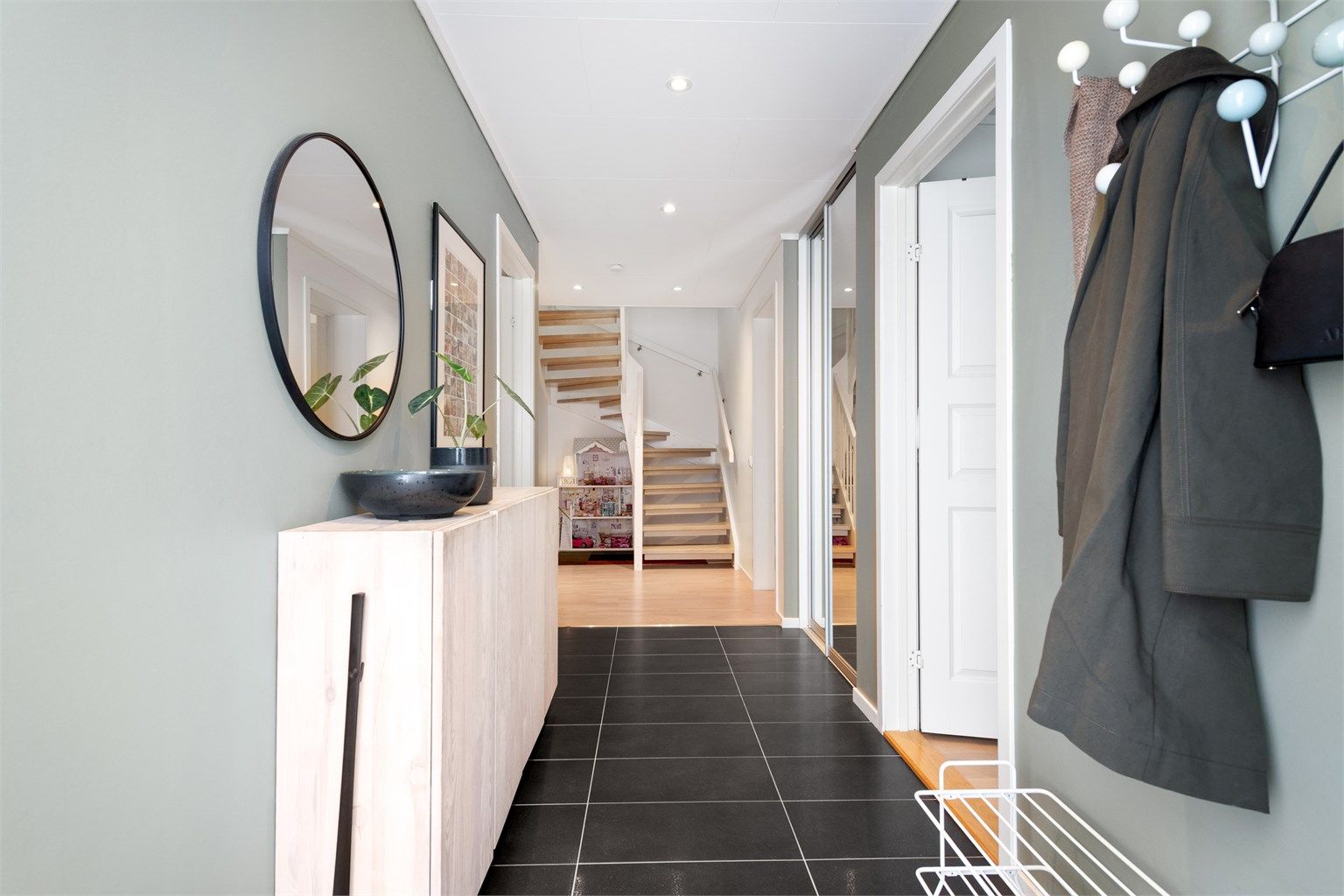 Fra gangen leder en solid tretrapp med åpne trinn deg videre opp til hovedetasjen.