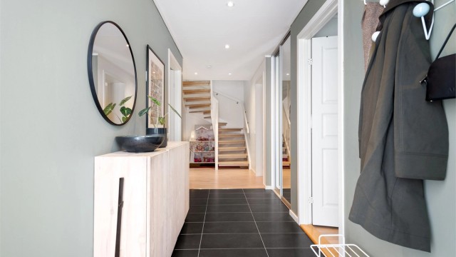 Fra gangen leder en solid tretrapp med åpne trinn deg videre opp til hovedetasjen.