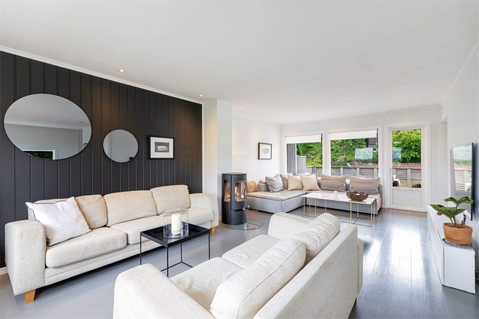 Stuen er romslig, med store vinduer som slipper inn rikelig med naturlig lys.