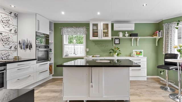 Romslig kjøkken med innredning fra 2015. Innredning med profilerte fronter med nedfelt oppvaskkum. Stein benkeplate. Oppvarming via gulvvarme og varmepumpe. Foto: Ole Thorgeir Solheim Thoresen