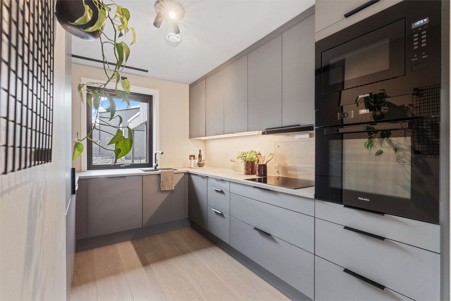 Benkeplate med laminert overflate og belysning under overskapene.