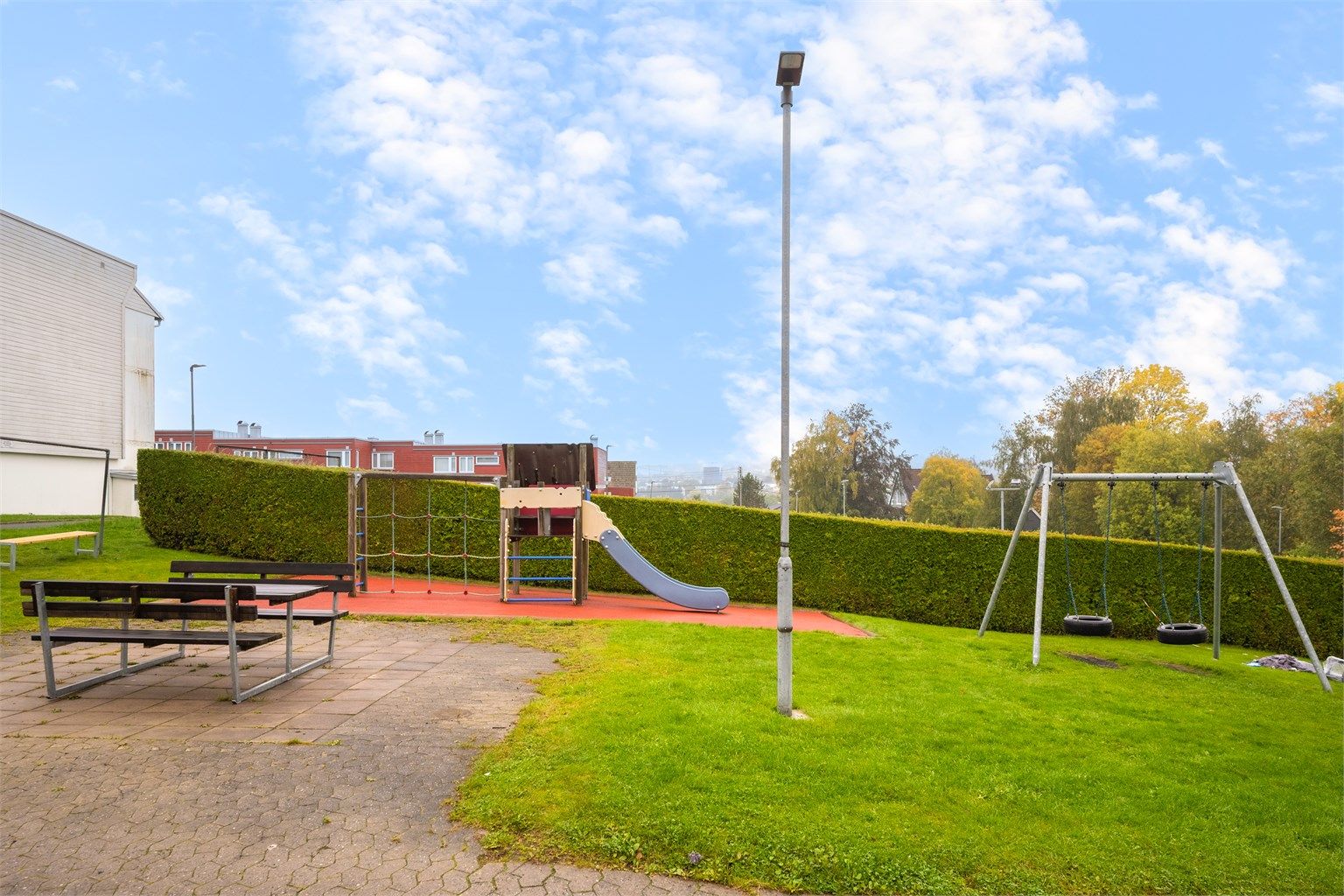 Felles lekeplass med husker, sklie og sittebenker ligger bare et steinkast unna, en populær møteplass for både små og store i nabolaget.