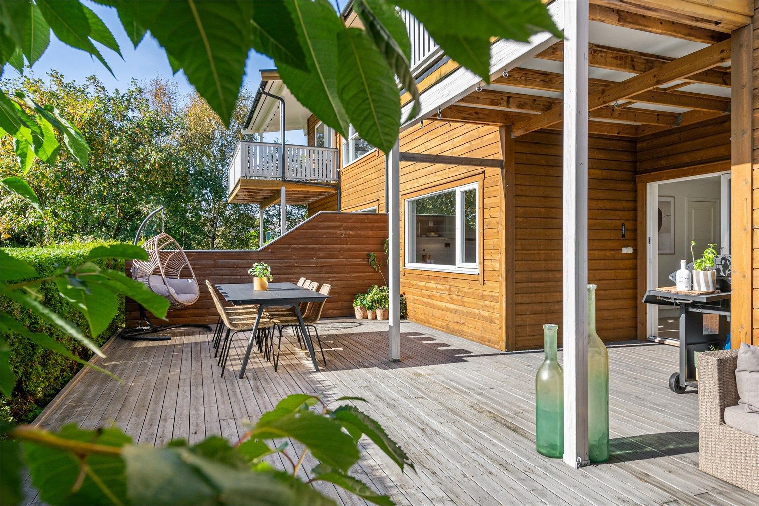 Terrassebord i trekonstruksjon med god plass til variert utemøblering.