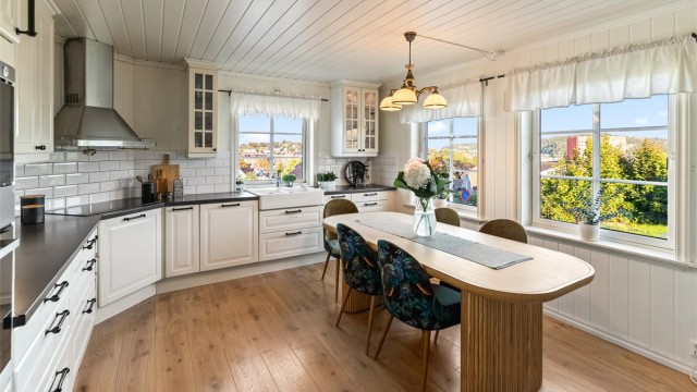 Lyst og pent kjøkken med innredning fra byggeåret, i klassisk og utførelse.