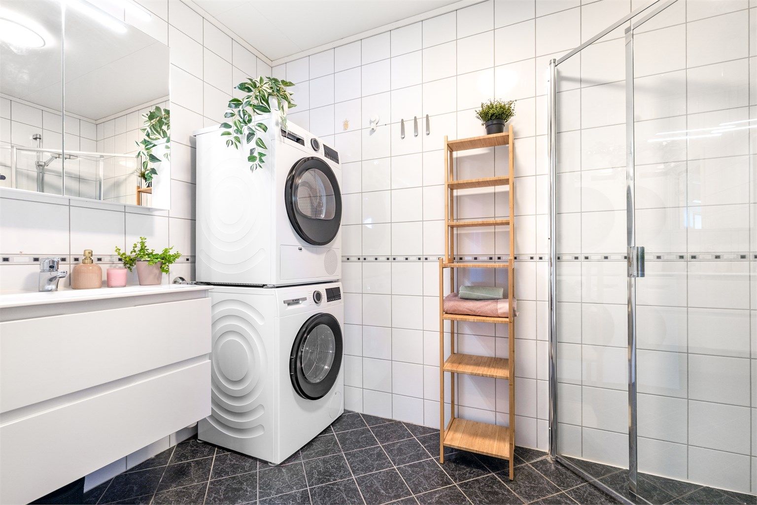 Baderomsinnredningen består av en servant med underskap og et speilskap med belysning.