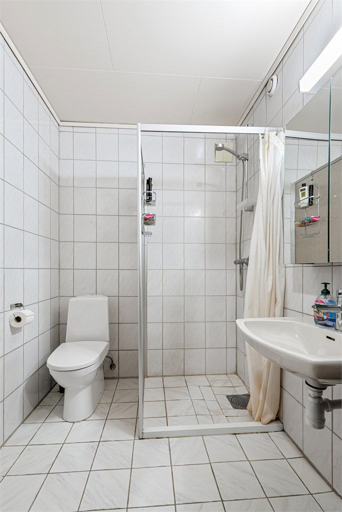 Flislagt bad i underetasjen med dusjnisje.