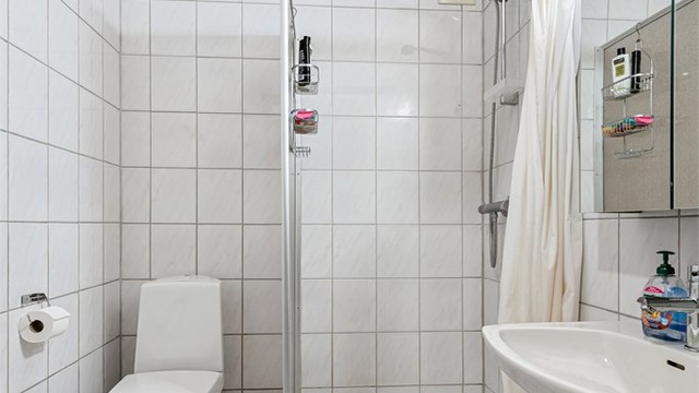 Flislagt bad i underetasjen med dusjnisje.