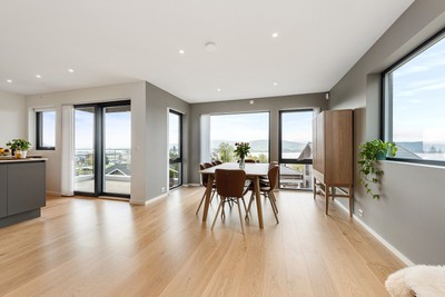 Stue og kjøkken i åpen løsning med gode lysforhold fra store vindusflater