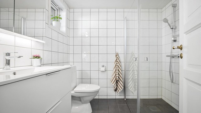 Flislagt bad med dusjhjørne og gulvvarme.