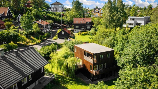 Boligen sett fra luften, omkranset av grønt.