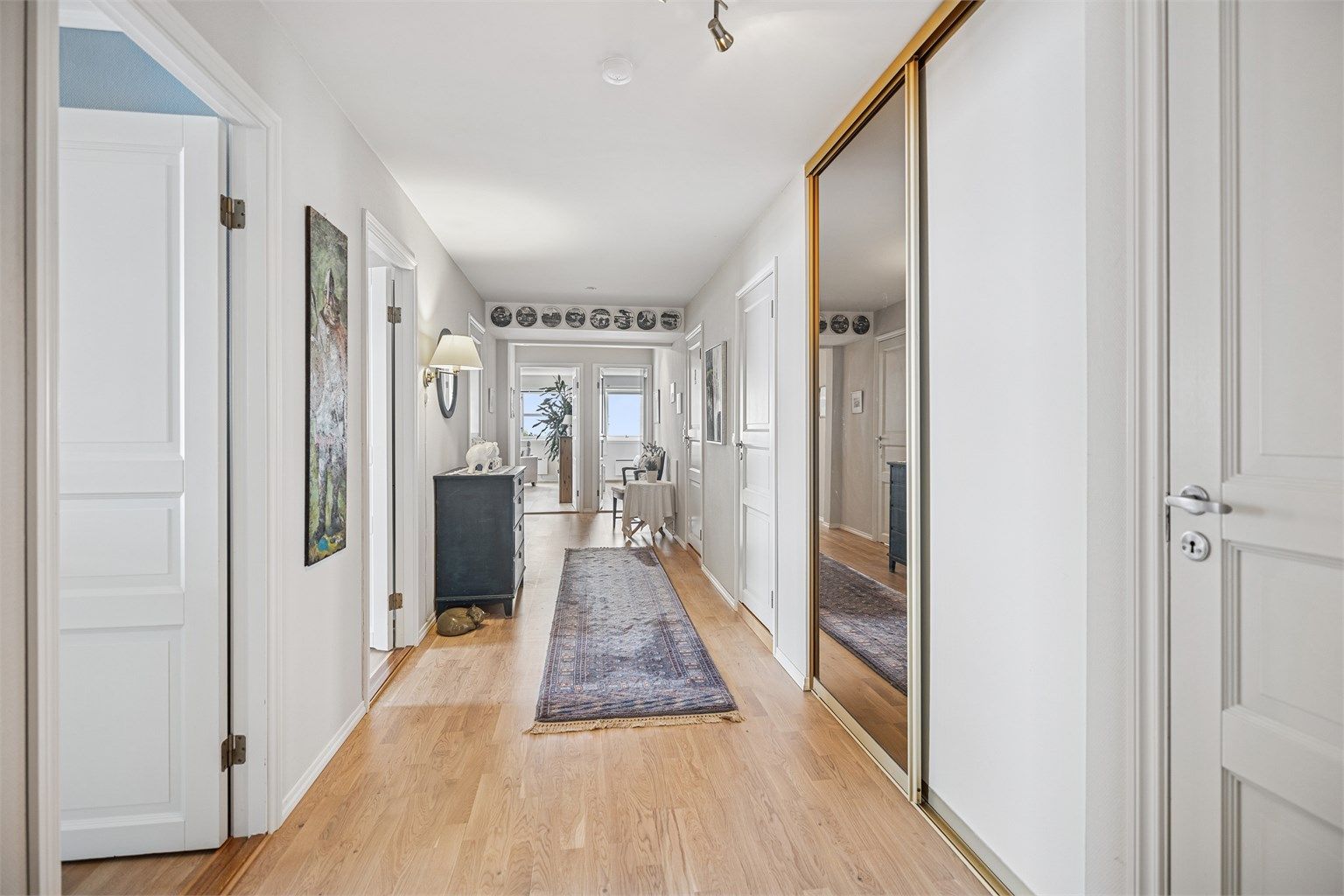 Boligen har en romslig entré/gang med gode muligheter for oppbevaring av yttertøy og sko i skyvedørsgarderobe med speildører.