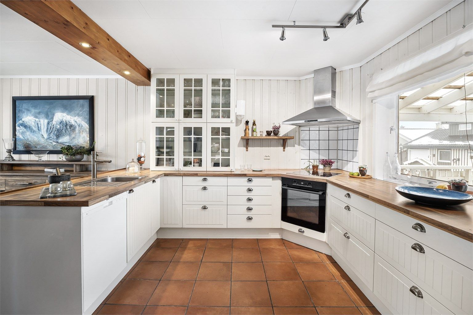 Flislagt felt på vegg ved stekeområde og god plass på arbeidsbenk. 