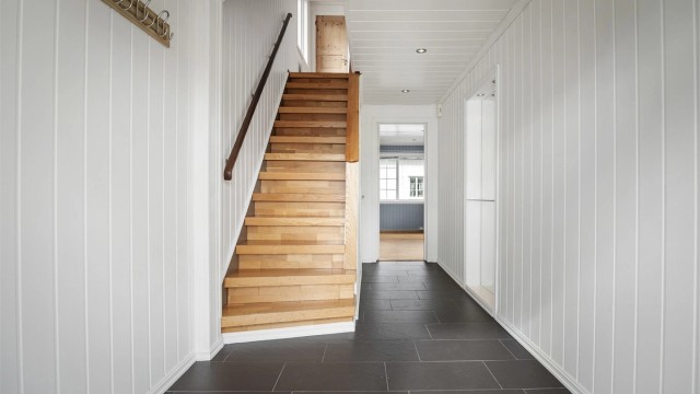 Entré med fliser på gulv og paneler på vegg og himling