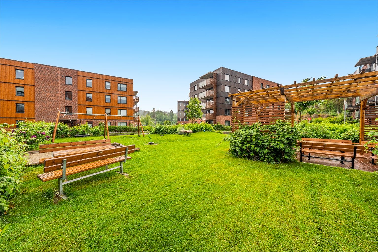 Fellesområdene er pent opparbeidet med plenarealer, beplantning og sittegrupper.