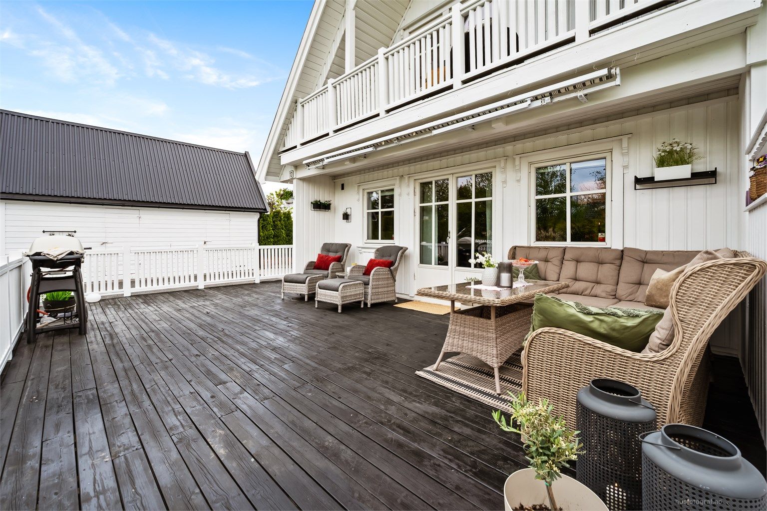 Verandaen er sammenhengende med plattingen ved inngangspartiet. Det er markise på verandaen.