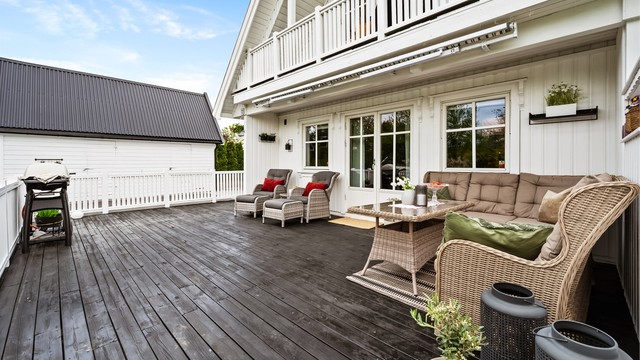 Verandaen er sammenhengende med plattingen ved inngangspartiet. Det er markise på verandaen.