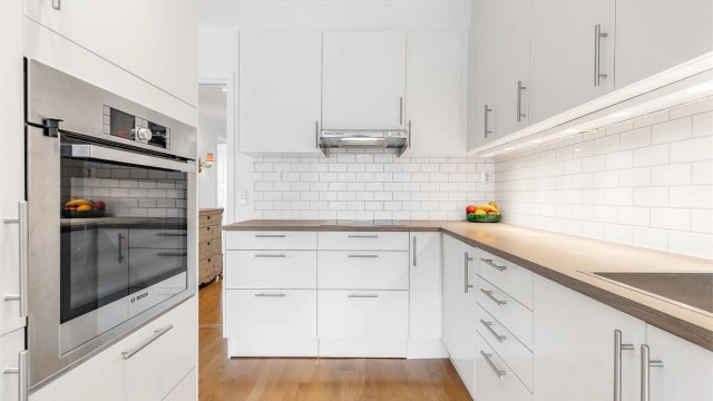 Lyst og moderne kjøkken med integrerte hvitevarer.